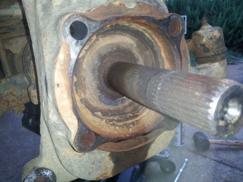 1988 Ford Bronco - Close-up of a heavily corroded vehicle wheel hub assembly and axle shaft.
