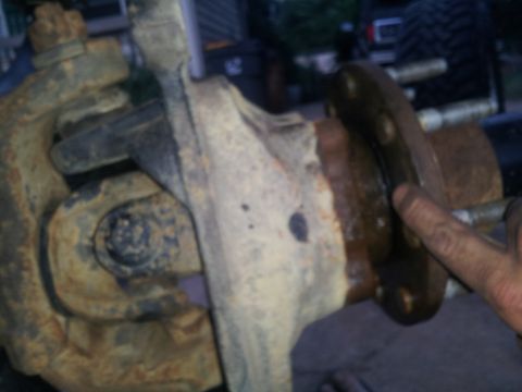 1988 Ford Bronco - Close-up view of a rusty vehicle suspension component, showing bolts and metal parts.