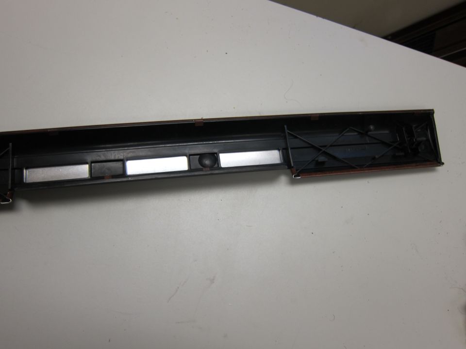 interior of a model train car with two rectangular silver inserts and a black ball