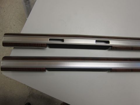 2001 Ford Crown Victoria - Two automotive interior door trim pieces are shown, one above the other, on a flat surface.