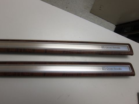 2001 Ford Crown Victoria - Two door trim pieces, each bearing the 'Crown Victoria' nameplate, feature a wood grain accent strip below a polished metal band.