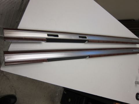 2001 Ford Crown Victoria - Two car door trim pieces with wood grain and chrome accents are displayed on a white surface.