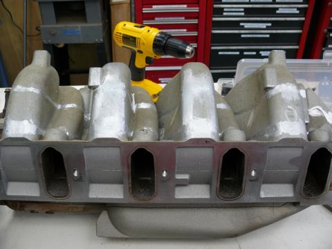 1976 Chevrolet Corvette - An aluminum intake manifold is shown with a yellow drill in the background.