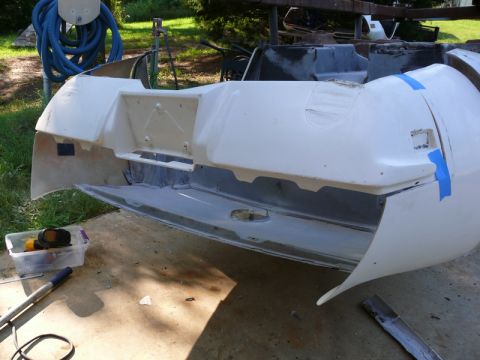 1976 Chevrolet Corvette - A disassembled car bumper is shown outdoors, with tools nearby and blue tape on the bodywork.