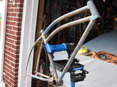 1994 Ford Bronco - A weathered bicycle frame, showing signs of rust and old paint, is held in a repair stand.