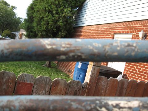 1994 Ford Bronco - A weathered fence with a 'Beware of Dog' sign is in the foreground of a backyard scene.