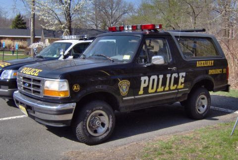 1992 Ford Bronco - Black Ford Bronco SUV marked as "POLICE" and "AUXILIARY EMERGENCY 50" sits parked.