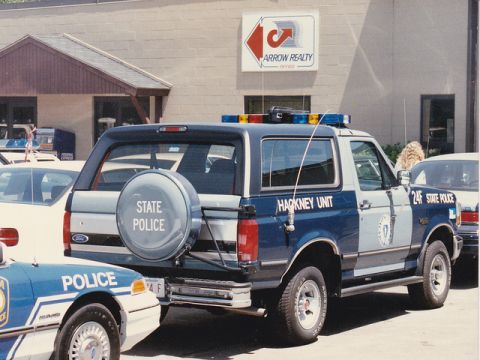 1992 Ford Bronco - State Police Ford Bronco and another police car parked outside Arrow Realty office.