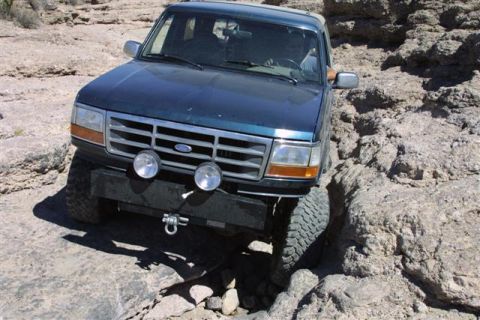 1994 Ford Bronco - Ford Bronco tackling a challenging off-road trail with large rocks.