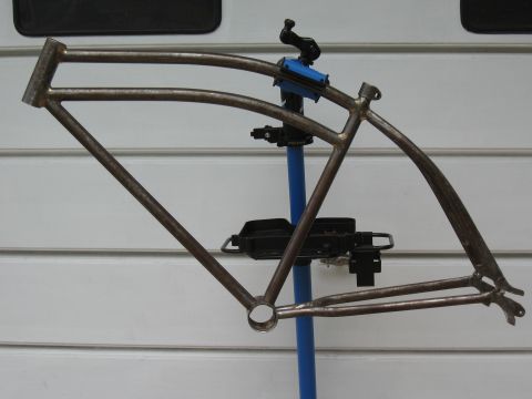 1994 Ford Bronco - A bare bicycle frame is held in a repair stand against a white paneled background.