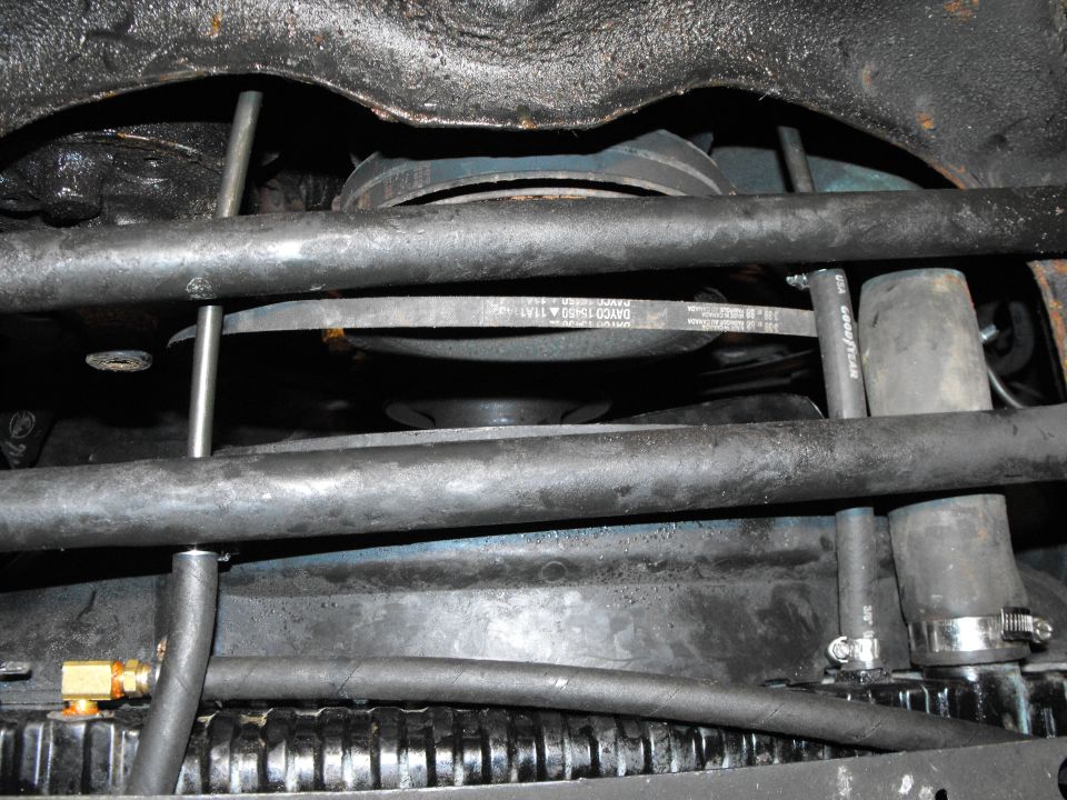 the hot transmission fluid is coming to the rad cooling loop from the front most fitting on the trans, to the fitting on the right side (in the pic). We're upside down so it is coming in to the passenger's side rad fitting via the 3/8" polyarmour line and the 7" of 3/8" hose. It would normally go out the left hand fitting, back to the rearmost trans fitting. You can see it's been replaced by a right angle fitting with a hose taking it to the "IN" nipple on the remote filter.