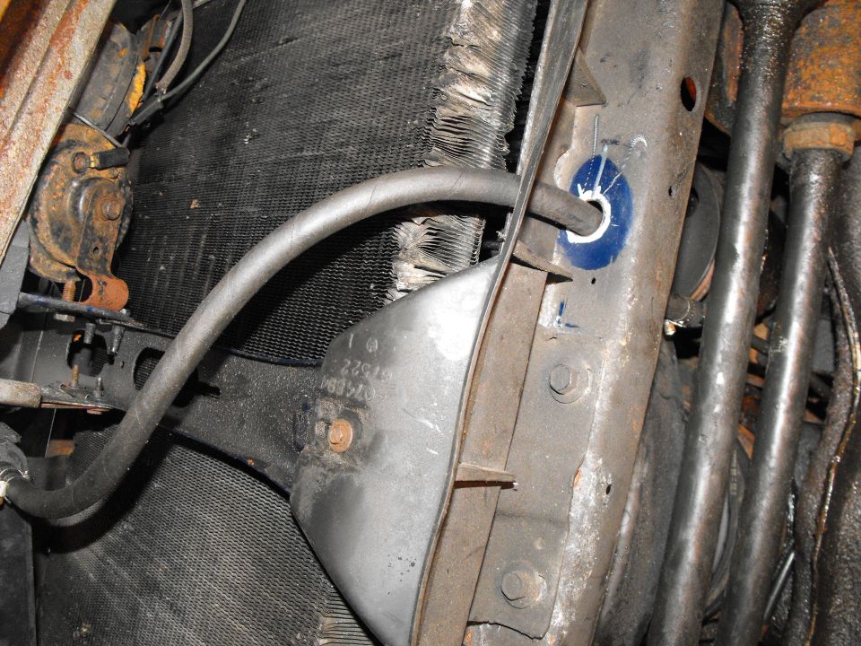 This hose complete's the circle, coimg out of the other side of the stacked plater cooler, routing through the chin spoiler, then through an existing hole in the lower rad support (I enlarged) and clamping right onto the return line which will take the extra cool, extra filtered ATF back to the rearmost transmission fitting.