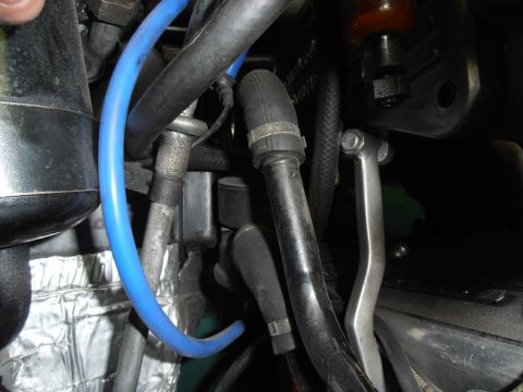 1990 Ford Bronco - Close-up view of engine bay components, including various hoses and metal parts.