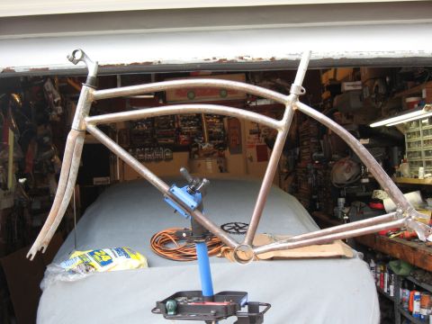 1994 Ford Bronco - A bare bicycle frame is clamped in a repair stand inside a garage, ready for assembly.