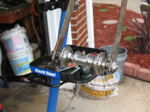 1994 Ford Bronco - A bicycle hub is shown on a repair stand, with buckets and a bag of sand in the background.