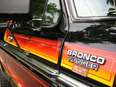 1994 Ford Bronco - Close-up of the side panel of a black Ford Bronco Ranger XLT, showing its distinctive stripe.