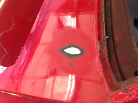1964 Ford Fairlane - This image shows a section of a car's body undergoing repair, with primer and filler applied to a damaged area.