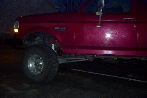 1994 Ford Bronco - This red Ford Bronco has a lifted suspension and large off-road tires.