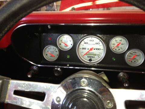 1964 Ford Fairlane - Aftermarket gauges replace the original dashboard instrumentation, showing speed, fuel, oil pressure, and water temperature.