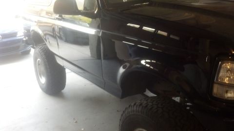 1995 Ford Bronco - This black SUV is shown from the side with a lifted suspension and large tires.
