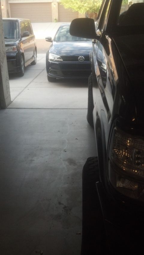 1995 Ford Bronco - A black SUV is parked in a garage, with a Volkswagen sedan and a Scion xB visible behind it.