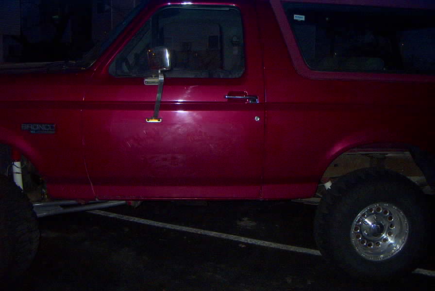 Red 1994 Ford Bronco side view with 'BRONCO' badge visible
