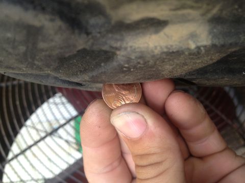 2000 Jeep Wrangler - A penny is used to show clearance under a vehicle's undercarriage, with a fan visible in the background.
