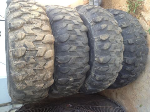2000 Jeep Wrangler - A set of four off-road tires are displayed, showing their deep, aggressive tread patterns.