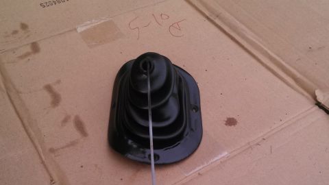 1979 Ford Bronco - A black rubber gear shifter boot is shown on a cardboard surface with handwritten text and a website logo.