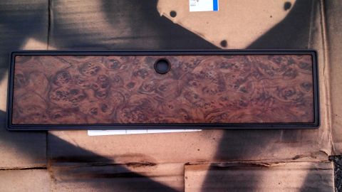 1979 Ford Bronco - This wood grain dashboard trim piece features a distinctive burl pattern and a central circular opening.