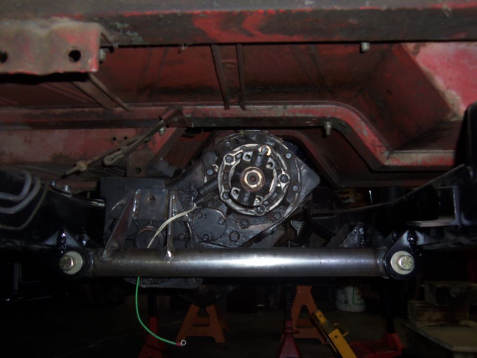 Underside view of a vehicle's transfer case and crossmember, with some wiring visible