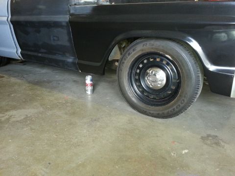 1967 Ford F-100 - Side view of a black truck, possibly a 1967 Ford F-100, with a beer can visible on the concrete floor.
