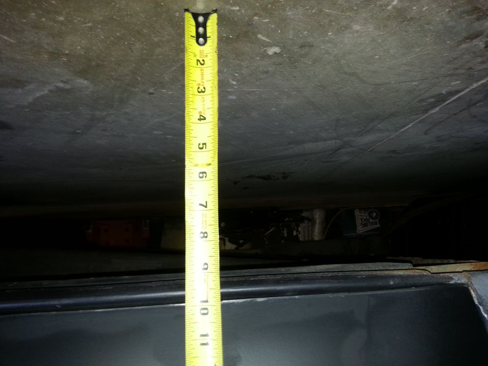 measuring tape showing about 11 inches of clearance under a vehicle part