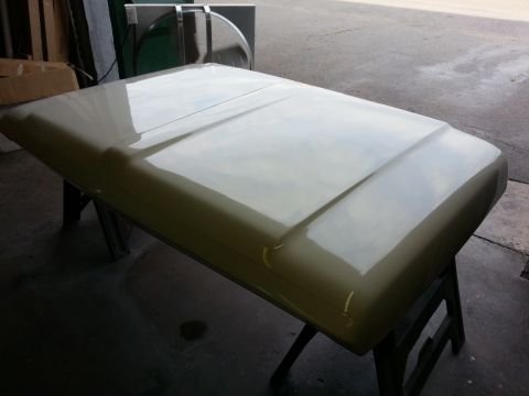 1967 Ford F-100 - A truck hood rests on sawhorses, reflecting light from above.
