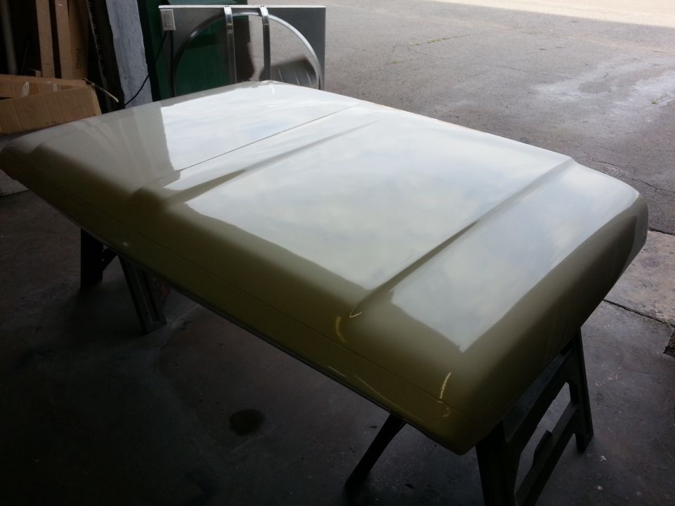 Light beige truck hood on sawhorses, showing a central raised ridge and curved edges