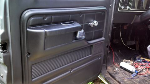 1979 Ford Bronco - Interior view of a 1979 Ford Bronco's door panel, revealing the dashboard and floor area.