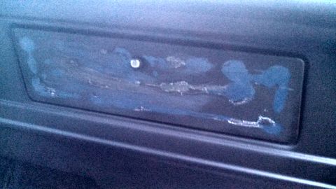 1979 Ford Bronco - A close-up view of a dark dashboard panel with smudges and a screw is visible.