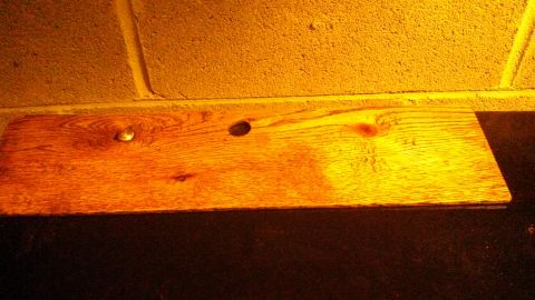 1979 Ford Bronco - A wooden plank with two holes and a screw is visible against a textured wall.