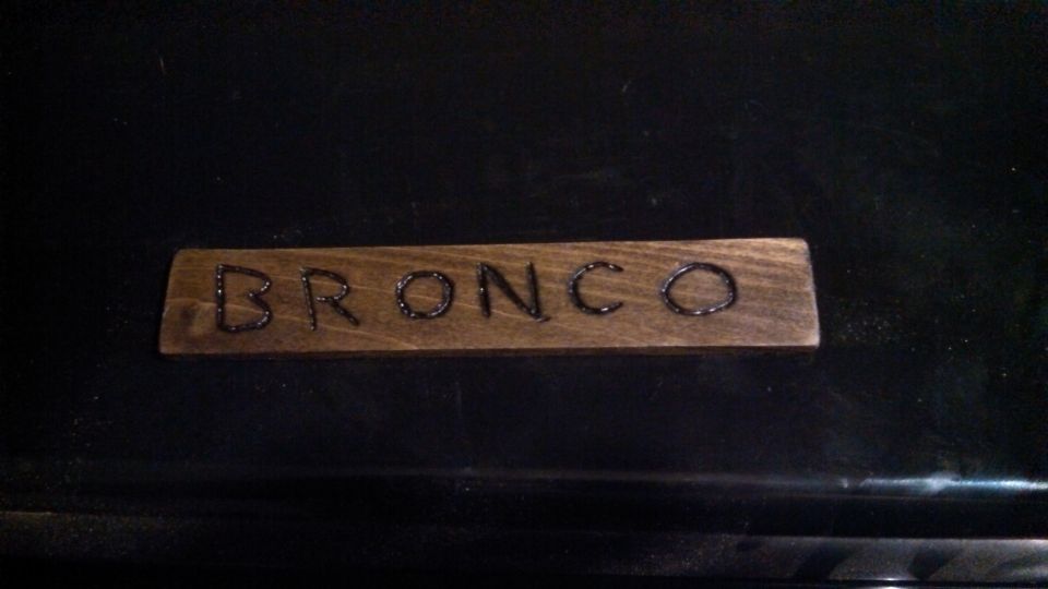 Wooden plaque with the word BRONCO carved into it