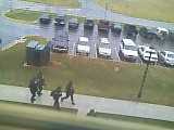 1979 Ford Bronco - Several people are running along a sidewalk adjacent to a wet parking lot filled with vehicles.