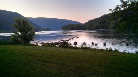 1979 Ford Bronco - A river scene at twilight, with hills and trees lining the banks under a soft sky.