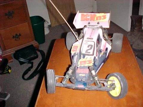 1995 Ford Bronco - A remote control buggy with racing decals sits on a wooden surface.