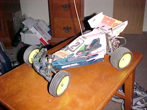 1995 Ford Bronco - A radio-controlled car with a blue and white body sits on a wooden table.