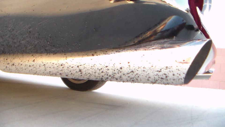 Close-up of dual chrome exhaust tips under a car's rear bumper
