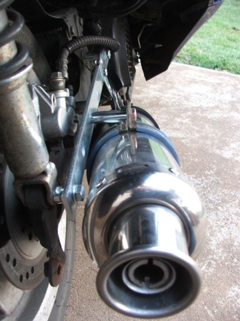 2008 Yamaha Zuma - A detailed view of a motorcycle's exhaust system, focusing on the muffler and rear wheel assembly.