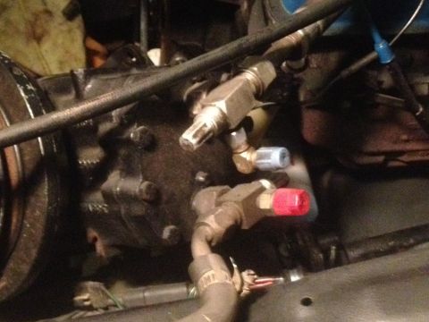 1978 Ford Bronco - Engine part with hoses and fittings, possibly part of an air conditioning system.