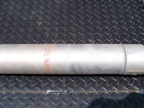 1999 Mercury Grand Marquis - Close-up of a vehicle exhaust pipe with a red marking on a textured metal background.
