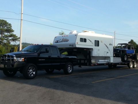 1967 Ford Mustang - A black pickup truck tows a large white camper and a blue Jeep on a trailer.