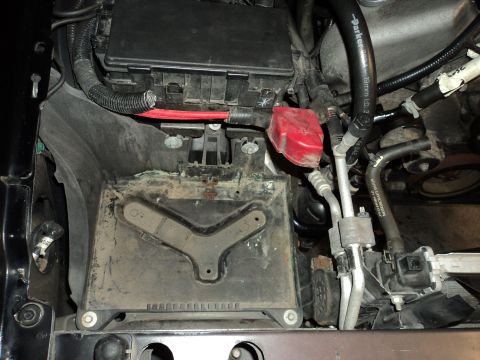 2004 Mercury Grand Marquis - Close-up view of the engine bay, focusing on the battery tray and associated electrical components.