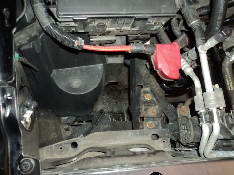 2004 Mercury Grand Marquis - Engine bay wiring and fuse box detail with red battery cable connection.
